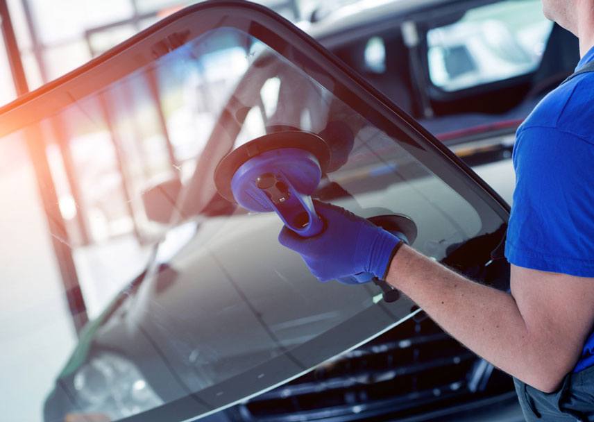 automobile worker replacing windscreen