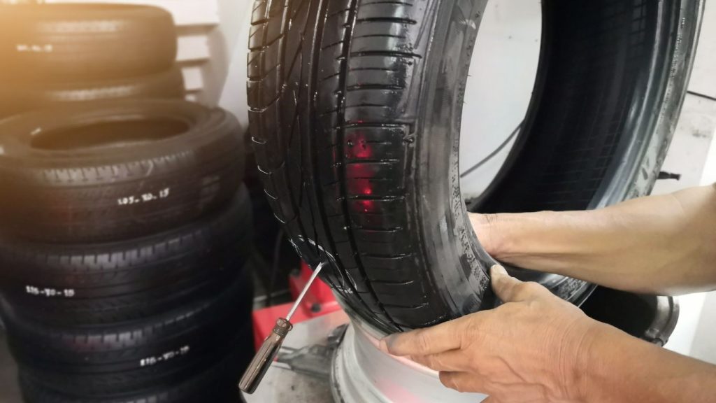 A mechanic repairing a car tire.